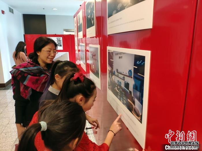 多伦多当地华人孩子仔细了解展出照片的内容。　毛建军 摄