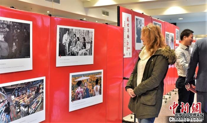 一位女性观众在观看对比上世纪50年代和今日中国女性展现旗袍风韵的一组照片。　金宏 摄